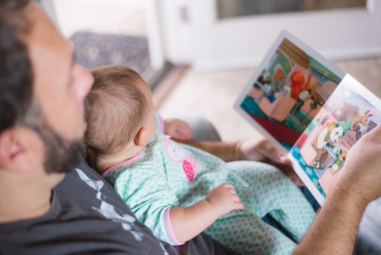 Dad and baby reading a book together