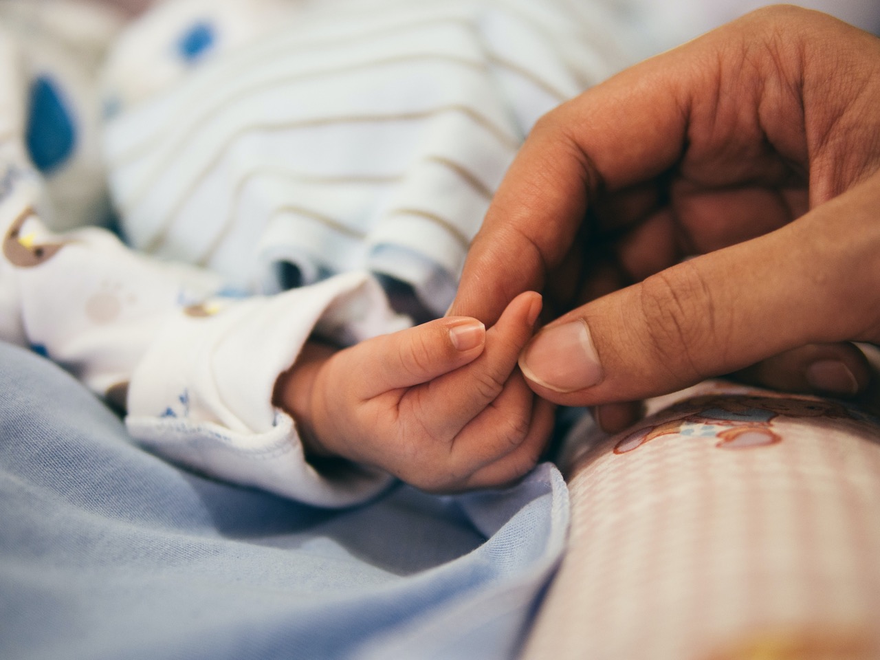 Mother and baby holding hands