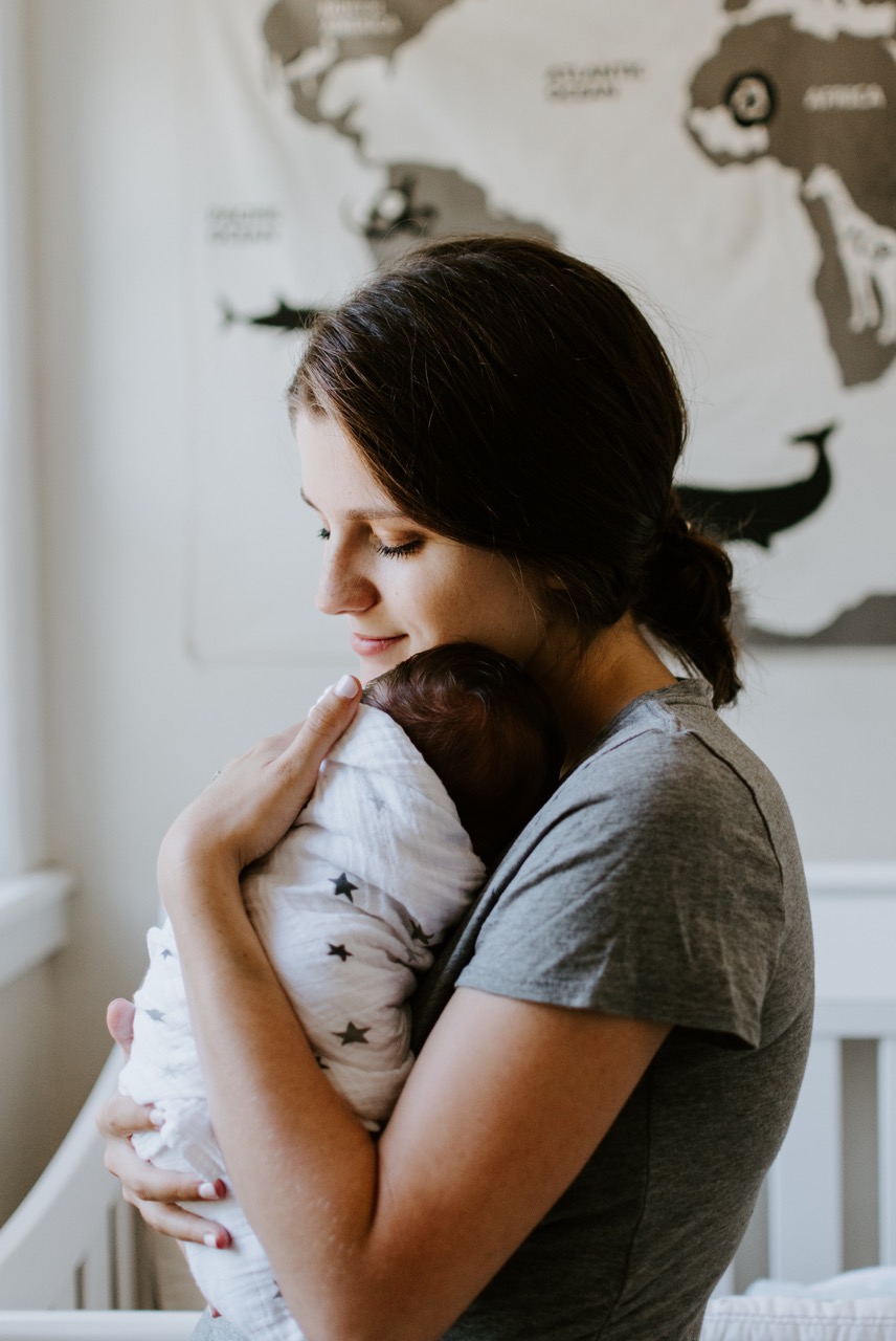 Mother cuddling a swaddled baby